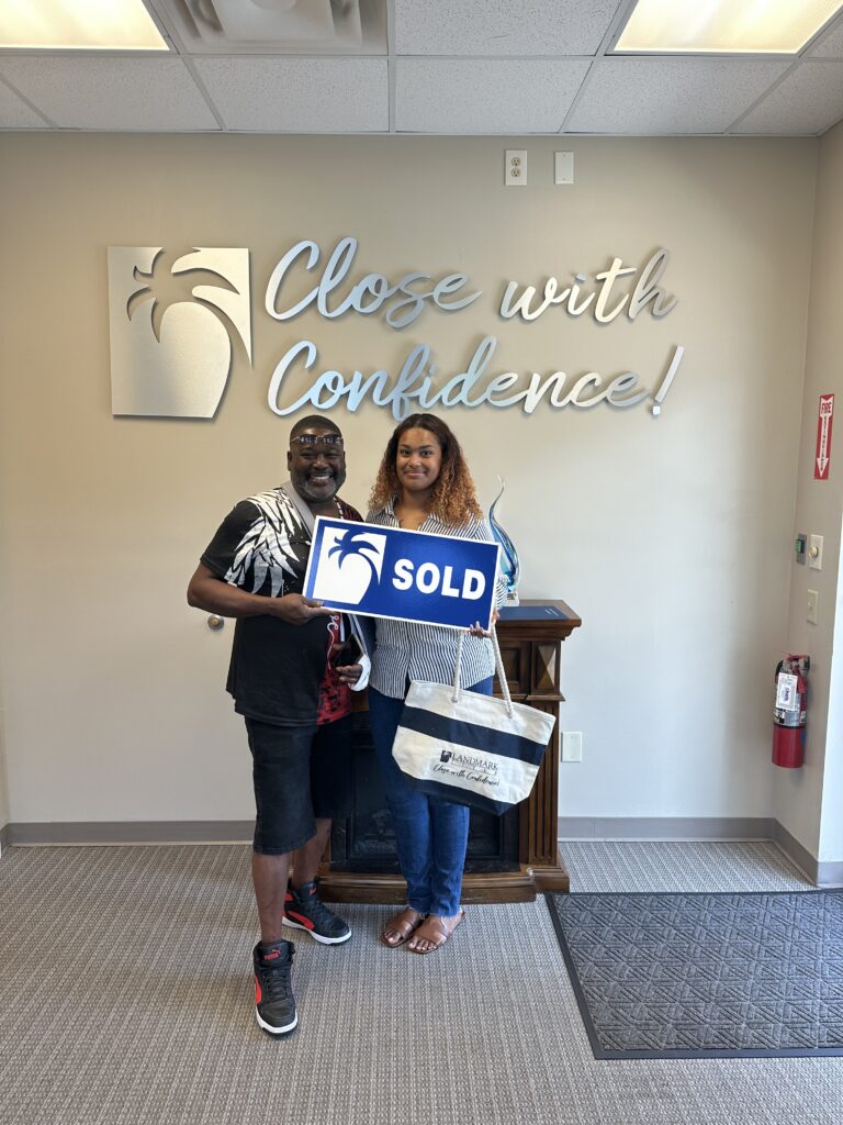 A happy client with Adriana Ellis-Footman holding a sold sign.